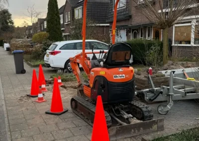 Mini-graafmachine voor rioolwerkzaamheden in woonwijk